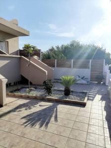 eine Terrasse mit zwei Topfpflanzen und einem Zaun in der Unterkunft #4 Giorgos & Chara apartments in Nea Kydonia
