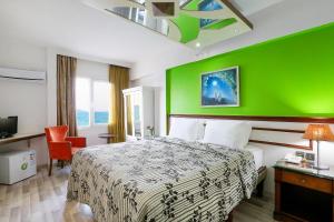 a hotel room with a bed and a green wall at URLA PERA HOTEL in Urla