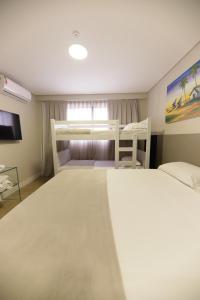 a bedroom with two bunk beds and a tv at Easy Suites Natal in Natal
