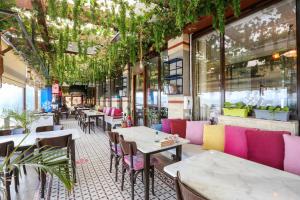a restaurant with pink and purple tables and chairs at URLA PERA HOTEL in Urla