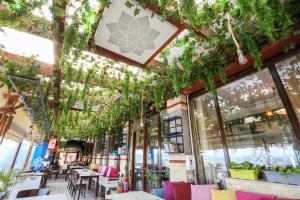 a restaurant with plants hanging from the ceiling at URLA PERA HOTEL in Urla