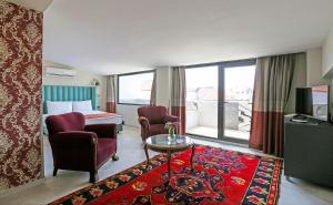 a hotel room with a bed and a table and chairs at URLA PERA HOTEL in Urla