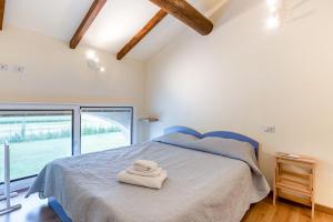 1 dormitorio con 1 cama con 2 toallas en Countryside Fiere Parma Apartments, en Certosino