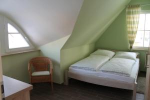 - une chambre avec un lit et une chaise dans l'établissement Fischer's Ferienhaus Rügen mit Sauna und Kamin, à Ummanz