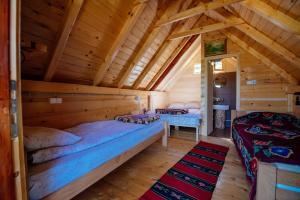 1 dormitorio con 2 camas en una cabaña de madera en Komovi - Kobil Do Guesthouse, en Kolašin