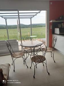 mesa y sillas en una habitación con ventana en Chez Brigitte, un séjour en Haute-Loire, en Saint-Germain-Laprade