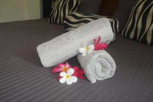 a towel on a bed with flowers on it at Hidden Villa in Hikkaduwa