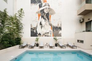 a mural of a woman on a wall next to a pool at The City Hotel & Suites in Rethymno