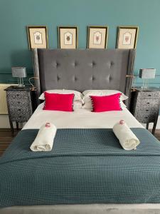 1 dormitorio con 1 cama grande con almohadas rojas en Albyn Townhouse, en Edimburgo