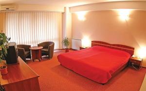 a hotel room with a red bed and chairs at HOTEL PHILOXENIA in Eforie Nord