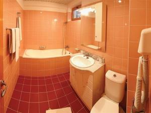a bathroom with a sink and a tub and a toilet at HOTEL PHILOXENIA in Eforie Nord