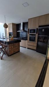 a kitchen with black appliances and a table in it at Casa do Sérgio temporada cantinho do sossego prainha de Mambucaba paraty in Paraty