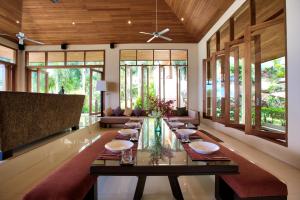 a dining room with a long table in a room with windows at Ban Reemo Luxury Villa in Bophut 