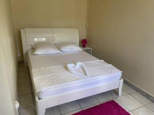 a bedroom with a white bed with a heart on it at Bas de villa couleuvre in Deshaies