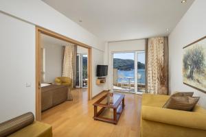 a living room with a couch and a table at Akrotiri Beach Resort Hotel - Adult Friendly in Paleokastritsa