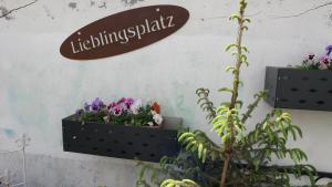 a sign on a wall with two plants and flowers at Ferienwohnung Rosenstadt in Forst