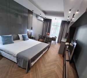 a bedroom with a large bed and a table at Central Plaza in Pomorie