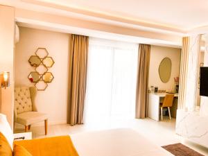 ママイア・ノルドにあるMamaia Moments Villa, Mamaia Nordのベッドルーム1室(ベッド1台、椅子、窓付)