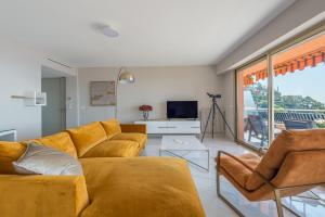 a living room with a couch and a television at Villefranche Bay View in Villefranche-sur-Mer