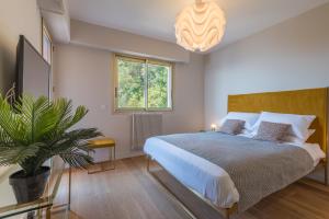 a bedroom with a bed and a potted plant at Villefranche Bay View in Villefranche-sur-Mer