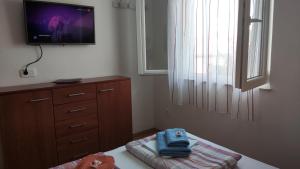 una camera da letto con una tv a parete e un letto di Rogoznica Seafront Apartment - Kalebova Luka a Rogoznica (Rogosnizza)