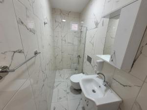 ein weißes Badezimmer mit Waschbecken und Toilette in der Unterkunft Cetin Pansiyon in Fethiye