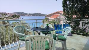 un tavolo e sedie su un balcone con vista sull'acqua di Rogoznica Seafront Apartment - Kalebova Luka a Rogoznica (Rogosnizza)
