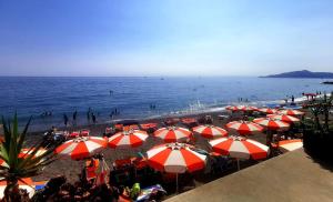 een groep parasols op een strand met de oceaan bij Terrazza Eugenia in Lavagna