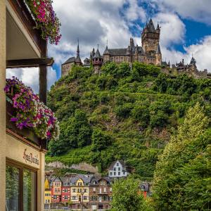 une ville sur une colline avec un château sur elle dans l'établissement Apartments Haus Daniela, à Cochem