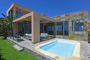 a house with a swimming pool in the yard at Salobre Los Lagos 26 in Maspalomas