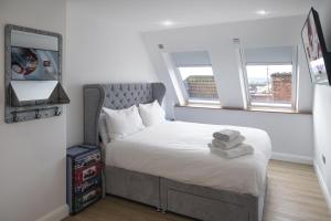 a small bedroom with a bed and two windows at no 1 Wood Street in Swindon