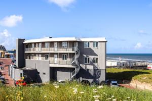 ein Gebäude mit einer Wendeltreppe am Meer in der Unterkunft Lido Zeezicht appartementen in Egmond aan Zee