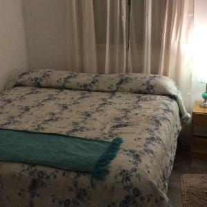 un letto con piumone blu e bianco e una finestra di Los Sunchos Casa de Campo a Ataliva