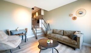 ein Wohnzimmer mit einem Sofa und einem Tisch in der Unterkunft Lido Zeezicht appartementen in Egmond aan Zee