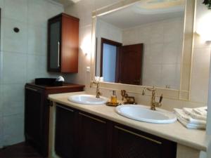 a bathroom with two sinks and a large mirror at La maison de Catherine in Volos +72 photos