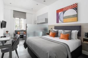 Schlafzimmer mit einem Bett, einem Schreibtisch und einem Stuhl in der Unterkunft Templeton Place by Supercity Aparthotels in London