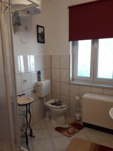 bagno con servizi igienici, lavandino e finestra di FeWo LoBec a Calau