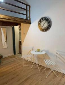 a clock on a wall with a table and chairs at Mascot bar street apartments in Rhodes Town