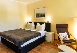 1 dormitorio con 1 cama y 1 silla en Apartment zum Wohlfühlen mitten im Grünen en Lindberg
