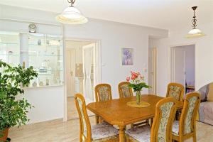 a dining room and living room with a wooden table and chairs at CSONTOS VENDÉGHÁZ in Hajdúszoboszló