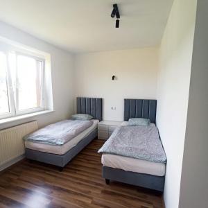 2 camas en una habitación con 2 ventanas en Nad Potokiem en Rydułtowy