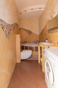 a bathroom with a tub and a sink and a washing machine at Apartament Stare Miasto in Elblag