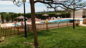 a swimming pool with people sitting around it at Hotel Valsequillo in Lepe