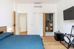 Un dormitorio con una cama azul y un televisor de pantalla plana. en Aurora Rooms, en Catania 23 fotos más