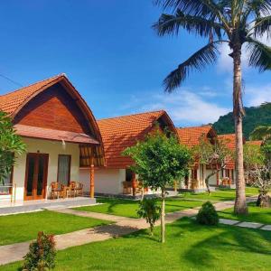 a house with a palm tree in the yard at The Tinsi in Nusa Penida