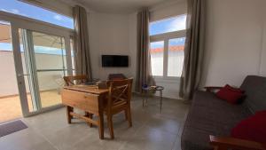 uma sala de estar com uma mesa, um sofá e uma televisão em Casa La Puntilla - Estudio Nº 1 em Valle Gran Rey