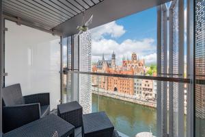 a balcony with chairs and a view of the city at Granaria Comfort Apartments in Gdańsk