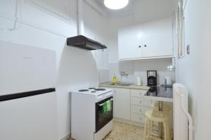 a kitchen with white cabinets and a stove top oven at A cozy minimal apartment at Koukaki, Dimitrako... in Athens