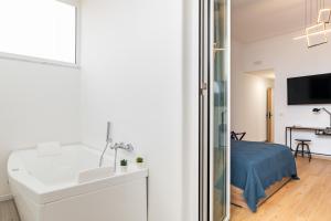 1 dormitorio y baño blanco con lavabo. en Aurora Rooms, en Catania