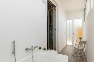 baño blanco con espejo y sofá blanco en Aurora Rooms, en Catania